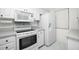 White kitchen with granite countertops and stainless steel appliances at 1501 Beach Rd # 209, Englewood, FL 34223