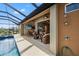 Relaxing pool area with covered lanai, wicker furniture, and outdoor shower at 15204 Aquarius Cir, Port Charlotte, FL 33981