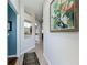 Hallway view leading to a bright kitchen with a decorative painting at 1577 Monarch Dr # 1577, Venice, FL 34293