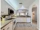 White kitchen with stainless steel appliances and view to living area at 1577 Monarch Dr # 1577, Venice, FL 34293