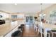 Open kitchen features white cabinets, island with seating, and access to dining area at 18198 Burkholder Cir, Port Charlotte, FL 33948