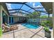 Enclosed pool and patio area with lounge chairs and dining table at 237 Albatross Rd, Rotonda West, FL 33947