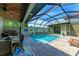 Enclosed pool area with patio furniture and grill at 237 Albatross Rd, Rotonda West, FL 33947