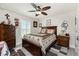 Bedroom with a ceiling fan, shuttered windows, and a bed with brown star-themed comforter at 25470 Palisade Rd, Punta Gorda, FL 33983