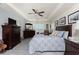 Bright main bedroom featuring a tray ceiling, shutters, wood-look flooring, and a seating area at 25470 Palisade Rd, Punta Gorda, FL 33983