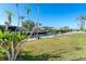 Waterfront backyard with a boat lift, green grass, and palm trees under a clear blue sky at 275 North Dr, Englewood, FL 34223