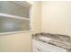 Bathroom with a white vanity, marble countertop, and a decorative window at 275 North Dr, Englewood, FL 34223