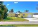 Charming single-story yellow home featuring a well-manicured lawn and attached garage at 275 North Dr, Englewood, FL 34223