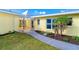 Close up of the front entrance with updated landscaping, sidewalk, and well-kept lawn at 275 North Dr, Englewood, FL 34223