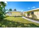 Inviting entrance with a concrete walkway leading to a screened-in porch and a beautiful lawn at 275 North Dr, Englewood, FL 34223