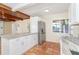 Open-concept kitchen offers terracotta floors, a stainless steel refrigerator, white cabinets, and stone countertops at 275 North Dr, Englewood, FL 34223