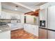 Spacious kitchen with terracotta tile, stone countertops, white cabinets, and stainless steel appliances at 275 North Dr, Englewood, FL 34223
