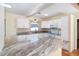 Modern kitchen featuring tile floors, white cabinets, stainless appliances, and marble countertops at 275 North Dr, Englewood, FL 34223