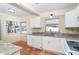 Bright kitchen features terracotta tile, stone countertops, white cabinets, and stainless steel appliances at 275 North Dr, Englewood, FL 34223