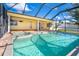 Enclosed pool area with a hot tub, and access to the home's yellow exterior at 275 North Dr, Englewood, FL 34223