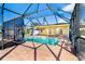 Screened-in pool with brick flooring and views of the backyard landscaping at 275 North Dr, Englewood, FL 34223