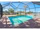 The screen-enclosed pool and patio offers a private oasis in a waterfront community at 275 North Dr, Englewood, FL 34223