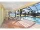 Screened-in lanai featuring a pristine pool overlooking the well maintained back yard at 275 North Dr, Englewood, FL 34223