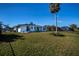 Spacious backyard with grassy lawn and palm tree at 30 Oakland Hills Pl, Rotonda West, FL 33947