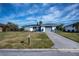 Single story home with a gray garage door and spacious front yard at 30 Oakland Hills Pl, Rotonda West, FL 33947