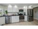 Modern white kitchen with stainless steel appliances and stone backsplash at 30 Oakland Hills Pl, Rotonda West, FL 33947