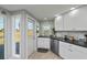 Bright kitchen with white cabinets, stainless steel appliances, and view of backyard at 30 Oakland Hills Pl, Rotonda West, FL 33947