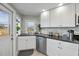 Corner kitchen with white cabinets, stone backsplash, and stainless steel appliances at 30 Oakland Hills Pl, Rotonda West, FL 33947