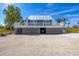 Charming elevated beach house with a metal roof and a deck overlooking the landscape at 331 Bocilla Dr, Placida, FL 33946