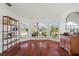 Bright living room boasts gorgeous wood floors and arched windows with views of the lush outdoors at 332 Comstock St, Port Charlotte, FL 33954