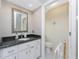 A bathroom with granite countertops, a decorative mirror, and a toilet in a separate water closet at 35 Sportsman Pl, Rotonda West, FL 33947