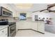 Well-lit kitchen featuring modern appliances, white cabinetry, and tile flooring at 36 Bunker Cir, Rotonda West, FL 33947