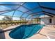 Swimming pool surrounded by a screened-in lanai and mature landscaping at 36 Bunker Cir, Rotonda West, FL 33947