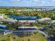 Scenic aerial view of condo complex, serene lake, lush landscaping, and covered parking spots at 4072 Oakview Dr # C8, Punta Gorda, FL 33980
