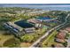 Expansive aerial view of the condo community featuring a lake, tennis court, and lush landscaping at 4072 Oakview Dr # C8, Punta Gorda, FL 33980