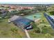 Aerial shot of the community pool, screened-in lanai, tennis court, and palm trees at 4072 Oakview Dr # C8, Punta Gorda, FL 33980