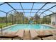 Enclosed rectangular pool with lounge chairs and a basketball hoop at 5 Broadmoor Ln, Rotonda West, FL 33947