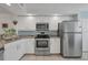 Stainless steel appliances and white cabinetry in this kitchen at 5725 Greenwood Ave # 8101, North Port, FL 34287