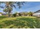 Expansive green backyard featuring mature palm trees and a screened in lanai at 604 Boundary Blvd, Rotonda West, FL 33947