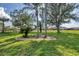 Manicured backyard with mature palm trees and lush green lawn at 604 Boundary Blvd, Rotonda West, FL 33947