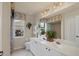 Bright bathroom with double sinks, white cabinets, large mirror, shower and neutral tile flooring at 604 Boundary Blvd, Rotonda West, FL 33947