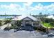 Community clubhouse featuring an American flag, lush landscaping, and ample parking at 604 Boundary Blvd, Rotonda West, FL 33947
