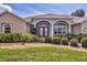 Charming home featuring a well-manicured lawn, lush bushes, and a welcoming facade with a two-car garage at 604 Boundary Blvd, Rotonda West, FL 33947