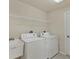Functional laundry room featuring washer, dryer, sink, overhead shelving and tile flooring at 604 Boundary Blvd, Rotonda West, FL 33947