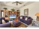 Inviting living room featuring a ceiling fan, entertainment center, and comfortable purple sofa at 604 Boundary Blvd, Rotonda West, FL 33947