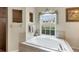 Inviting main bathroom featuring a large soaking tub with a picturesque window view at 604 Boundary Blvd, Rotonda West, FL 33947