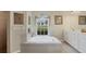 Bright main bathroom featuring a large soaking tub with tile surround and large window at 604 Boundary Blvd, Rotonda West, FL 33947