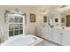 Relaxing main bathroom with dual sink vanity, large mirror, and soaking tub at 604 Boundary Blvd, Rotonda West, FL 33947