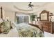 Comfortable main bedroom featuring a ceiling fan, tropical decor, and backyard views at 604 Boundary Blvd, Rotonda West, FL 33947