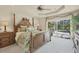 Spacious main bedroom boasting a four-poster bed, ceiling fan, and sliding glass doors to the pool at 604 Boundary Blvd, Rotonda West, FL 33947