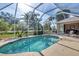 Relaxing screened-in pool with ample deck space for entertaining and lounging near lush landscaping at 604 Boundary Blvd, Rotonda West, FL 33947